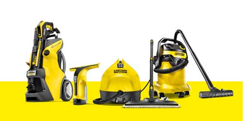 A Kärcher high-pressure cleaner being used to clean a dirty pavement.